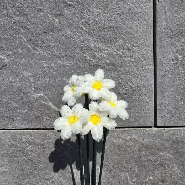 Ramillete artesanal de margaritas blancas pequeñas con centro amarillo en tallo verde