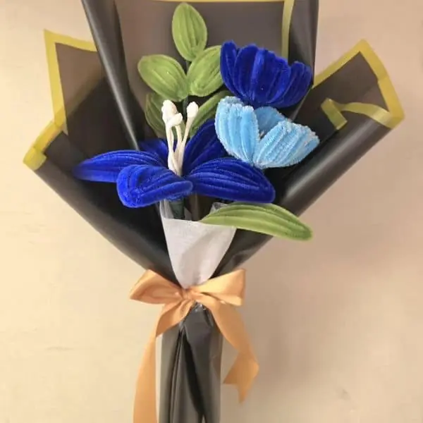 Ramo Ejecutivo con amapolas azul navy y flor celeste en envoltura negra